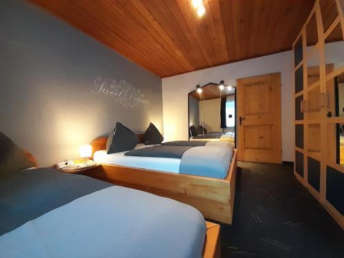 - une chambre avec 2 lits et un miroir dans l'établissement Haus Rosina, à Mühlbach am Hochkönig