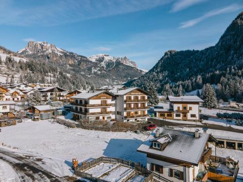 a village in the mountains with snow on the ground at Hotel Garnì Rosengarten in Pera