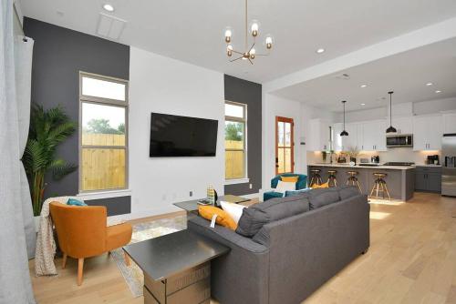 a living room with a couch and a kitchen at Blissful Getaway Home with Hot Tub & Backyard Near Downtown in Houston