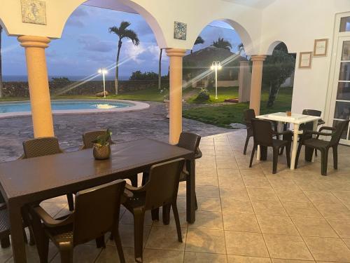 a patio with tables and chairs and a pool at Ocean Breeze Villa Carismar in Cabrera