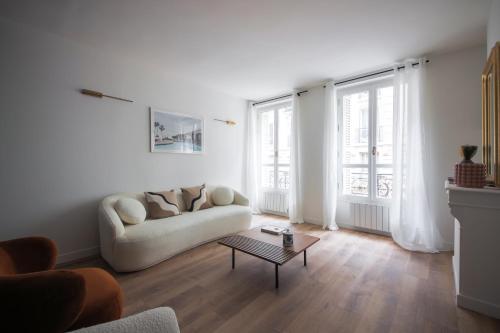 un salon blanc avec un canapé et une table dans l'établissement 1#Appart 4Pers#2 Chambres#Commerce#FullEquipped#AC, à Paris