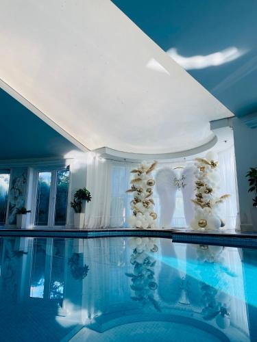 a room with a swimming pool with a table and a ceiling at Fruška Gora Klub Krstašice in Irig
