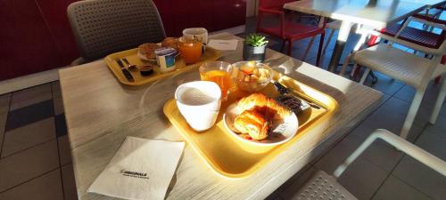 a table with a tray of food on it at The Originals Access, Hôtel les Iris, Berck-sur-Mer in Berck-sur-Mer