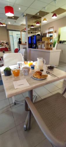 a table with food on it in a restaurant at The Originals Access, Hôtel les Iris, Berck-sur-Mer in Berck-sur-Mer