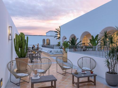 une terrasse avec des tables et des chaises dans l'établissement Tropicana Los Cabos, à San José del Cabo