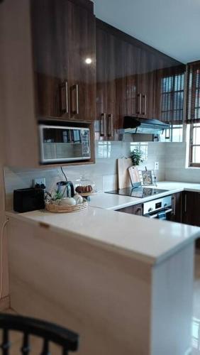 a kitchen with wooden cabinets and a white counter top at Mkababa's beautiful and spacious in Durban