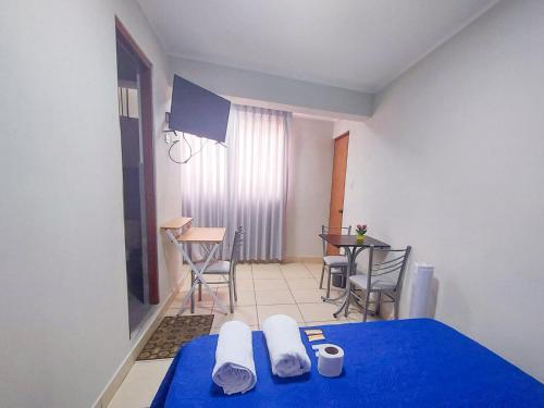 um quarto com uma cama azul, uma mesa e cadeiras em Residencia Benavides em San Vicente de Cañete