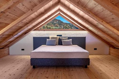 a bedroom with a bed with a large window at Spornberg Mountain Living Nordberg in Soprabolzano