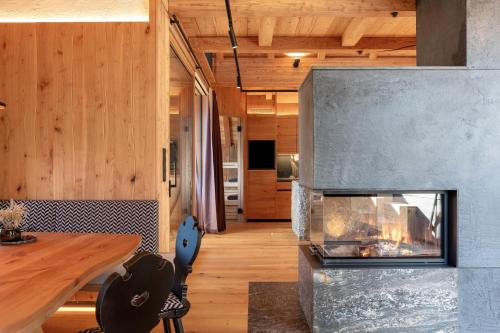 a living room with a fireplace and a table at Spornberg Mountain Living Nordberg in Soprabolzano