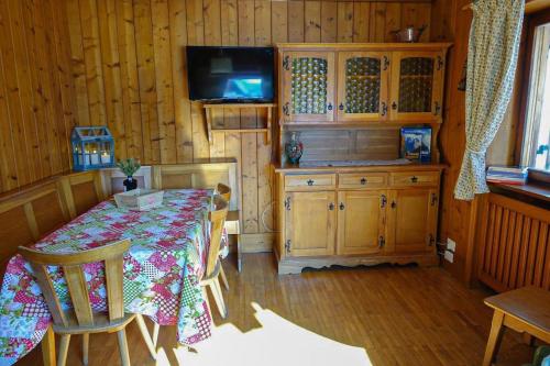 uma sala de jantar com uma mesa e uma televisão num camarote em Relax a Cortina d'Ampezzo - Alverà em Cortina dʼAmpezzo