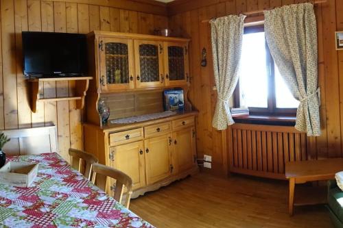 une salle à manger avec une télévision et une table à manger dans l'établissement Relax a Cortina d'Ampezzo - Alverà, à Cortina dʼAmpezzo