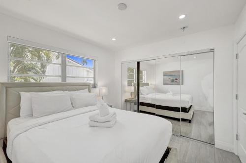 a white bedroom with a large bed and a mirror at Luxurious Villa with Pool in Hollywood