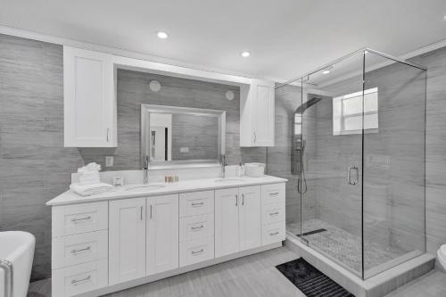 a white bathroom with a shower and a sink at Luxurious Villa with Pool in Hollywood