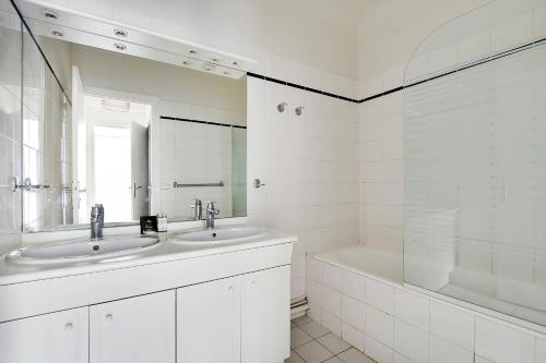 a white bathroom with two sinks and a tub at CMG Tour Eiffel/ New York in Paris