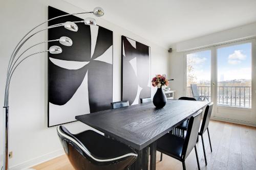 a dining room with a table and chairs and a vase with flowers at CMG Tour Eiffel/ New York in Paris