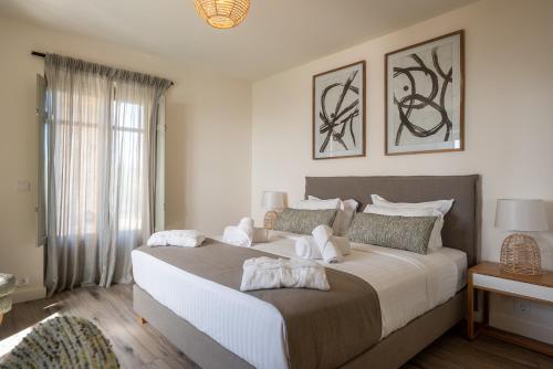 a bedroom with a large bed with two stuffed animals on it at Katergo Luxury Villas in Stoupa
