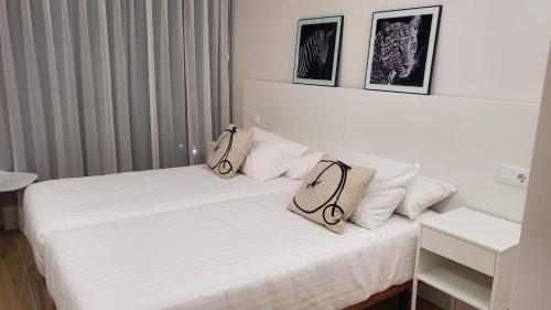 a white bed with two bags on top of it at Cíes Luxury Suitel Lily Rodsen - Love your Stay in Vigo