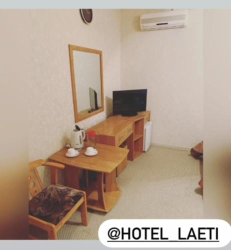 a room with a desk with a mirror and a television at Laetu in Atyraū