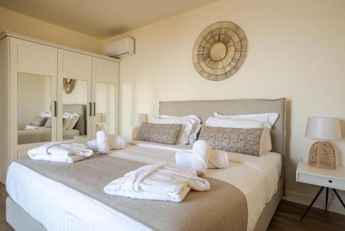 a bedroom with a large bed with towels on it at Katergo Luxury Villas in Stoupa