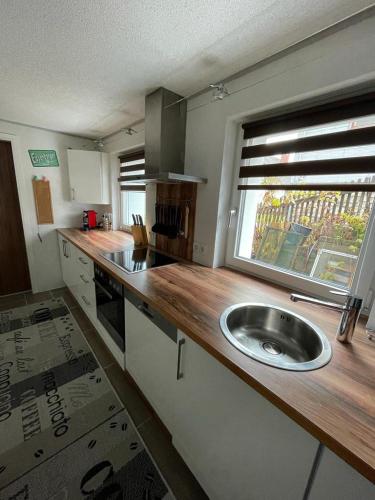 a large kitchen with a sink and a window at Dambach Appartement in Rossleithen