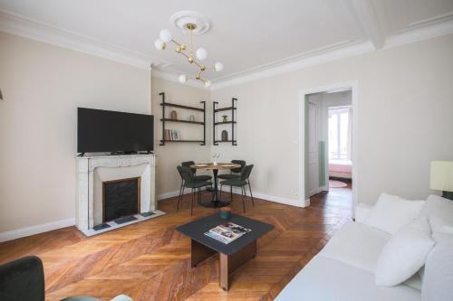 un salon avec un canapé blanc et une cheminée dans l'établissement 2#Appart 6Pers#2 Chambres#Commerce#FullEquipped#AC, à Paris