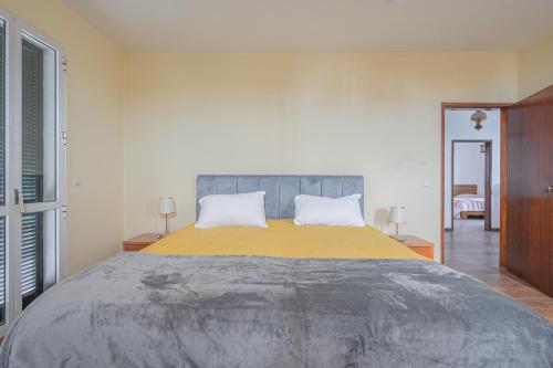 a bedroom with a large bed with a yellow blanket at Villa Familia Dehoux in Camacha