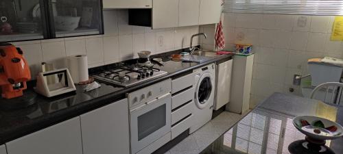 a kitchen with a stove and a washing machine at Casa vacanze Puccini in Lecce