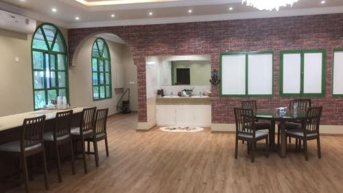 a dining room with a brick wall and a table and chairs at Big Guest House - استراحة كبيرة in Al Ḩamīdīyah