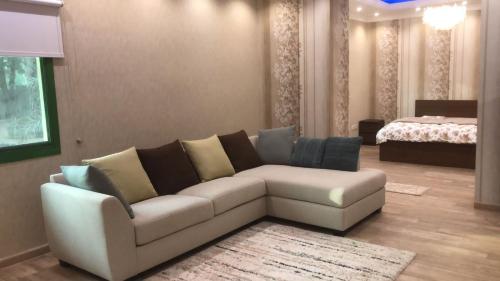 sala de estar con sofá y cama en Big Guest House - استراحة كبيرة en Al Ḩamīdīyah