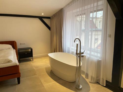 La salle de bains est pourvue d'une baignoire à côté d'une fenêtre. dans l'établissement Apartamenty Jezuicka 16, à Bydgoszcz