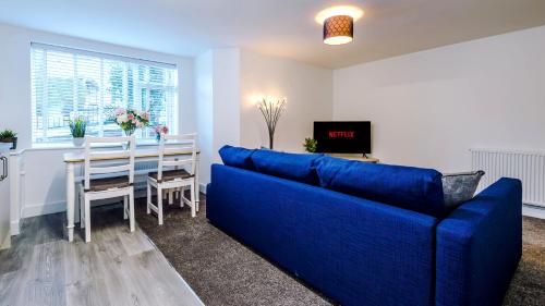 a living room with a blue couch and a table at Stylish Modern Apartment in Conwy in Conwy