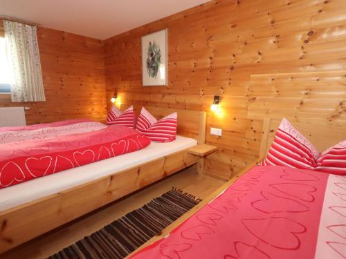 a bedroom with two beds in a log cabin at Kometer App Edelweiss in Fendels