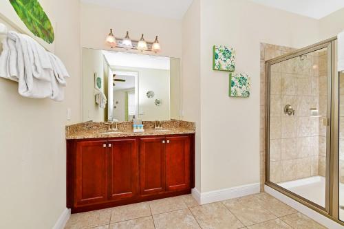 La salle de bains est pourvue d'un lavabo, d'une douche et d'un miroir. dans l'établissement Splendid Home by Rentyl with Private Pool near Disney - 430N, à Orlando