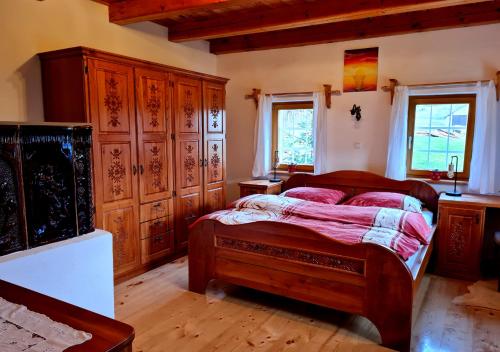 een slaapkamer met een bed en houten kasten bij Turistična kmetija Hiša ob gozdu pri Ptuju in Ptuj