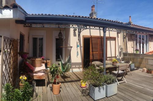 un patio avec une terrasse en bois agrémentée de plantes. dans l'établissement Chambre calme indépendante avec Salle de bains -Petit déjeuner-Grande Terrasse- Proche du centre, à Bordeaux