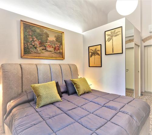 un grande divano viola in una stanza con un dipinto di PALAZZO TESTA - LOCAZIONE TURISTICA a Firenze