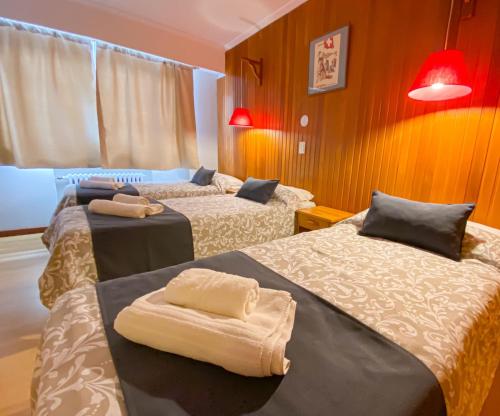 Habitación con 2 camas y toallas. en Hostería Suiza - Ex Casita Suiza en San Carlos de Bariloche