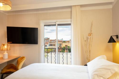 a hotel room with a bed and a window at Hôtel Escaletto in Aix-en-Provence