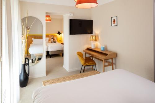 ein Hotelzimmer mit einem Bett und einem Schreibtisch mit einem Spiegel in der Unterkunft Hôtel Escaletto in Aix-en-Provence
