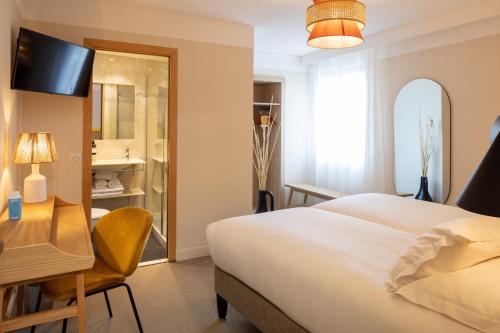 a hotel room with a bed and a desk and a mirror at Hôtel Escaletto in Aix-en-Provence