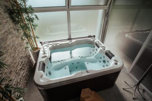 a bath tub in a room with a window at Apartments & Wellness Skok in Mozirje
