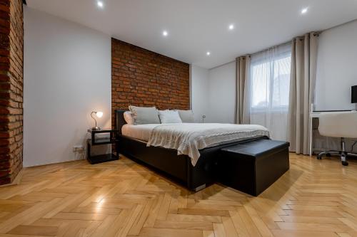 a bedroom with a bed and a brick wall at Luxury Apartment in the City Centre in Košice