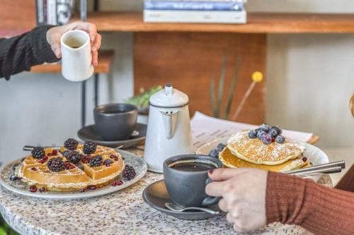 a table with pancakes and a cup of coffee at Hotel Alameda, Highline in New York
