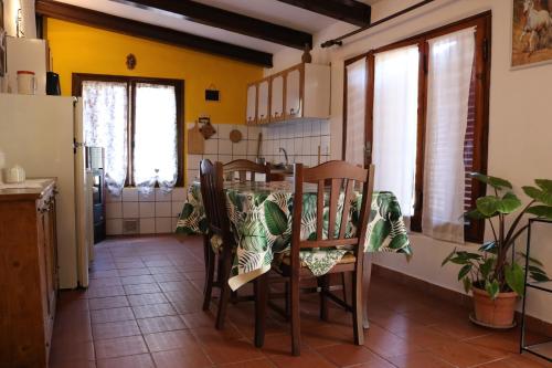 ラポラーノ・テルメにあるAppartamento Boscodisottoのキッチン(テーブル、椅子付)