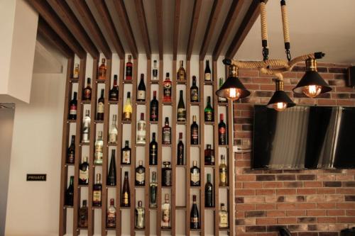 a wall of wine bottles on a wall at Eleon Motel in Brezovicë