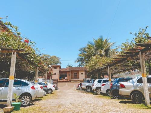 a row of cars parked in a parking lot at Chalés Sununga Flats a 1 minuto da praia in Ubatuba