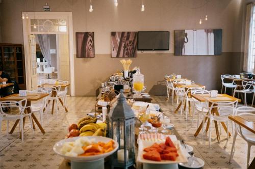 una habitación con mesas y sillas con comida. en NHM Hotel, en Araraquara