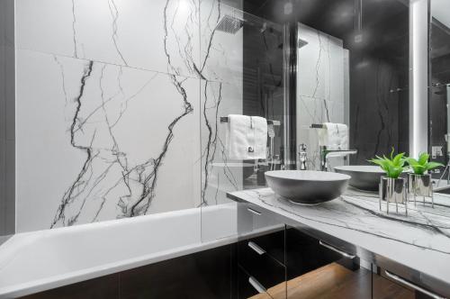 - czarno-białą łazienkę z umywalką i lustrem w obiekcie Apartament Tokyo HANZA POOL w Szczecinie