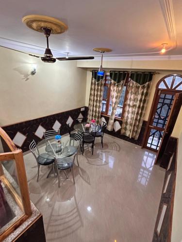 a dining room with a glass table and chairs at YATIKA HOMESTAY in Shimla