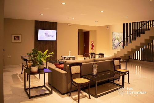 a living room with a couch and a table with chairs at Las Hortensias Hotel in Monteros